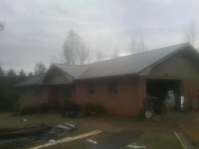 Gray metal roof on a stucco house with an attached garage in Millville